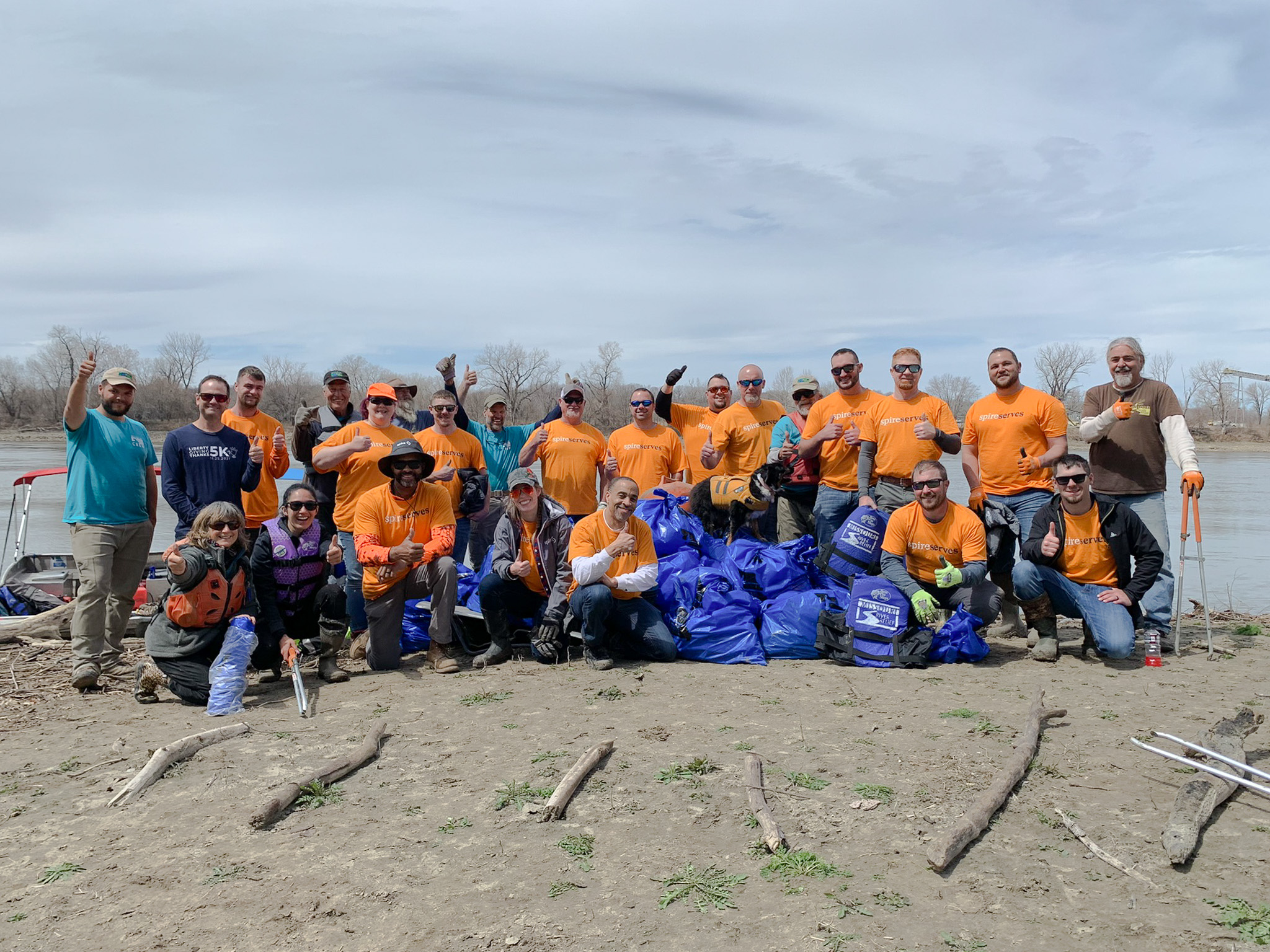 group standing in front of river for cleanup