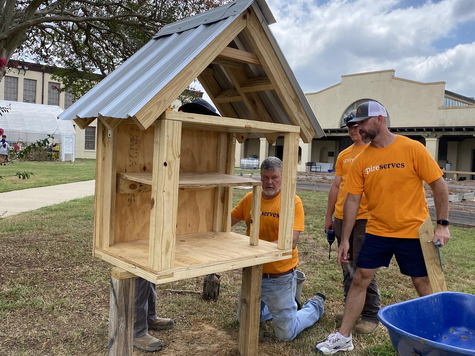 Image of Spire employees volunteering and building a greenhouse