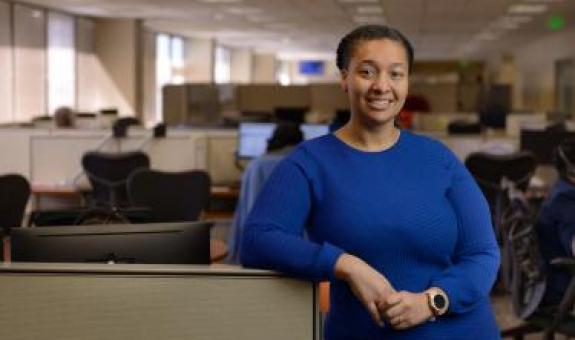 Spire employee standing in front of workspace