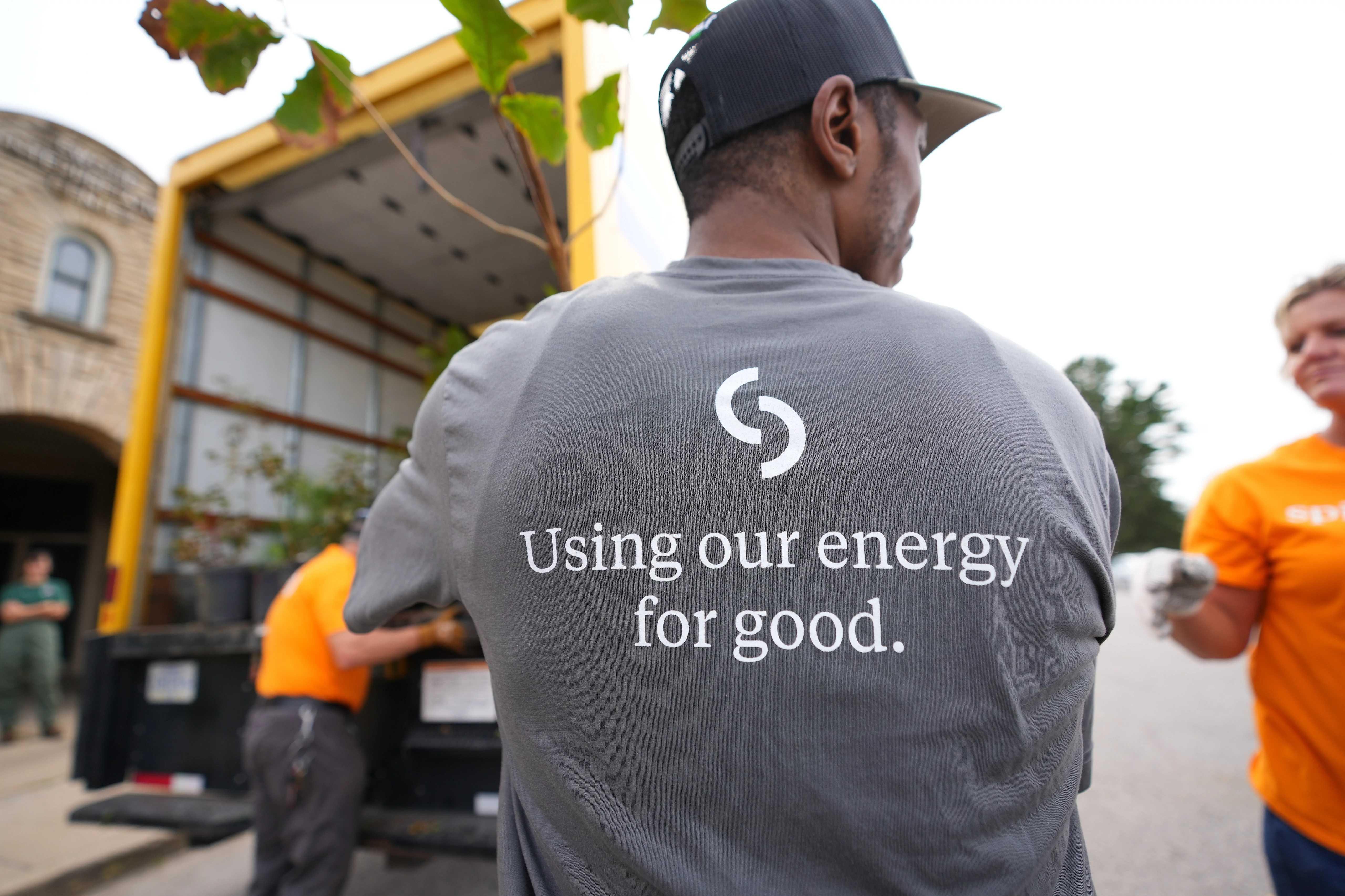 Image of Spire employee volunteering. His shirt says "Using our energy for good"