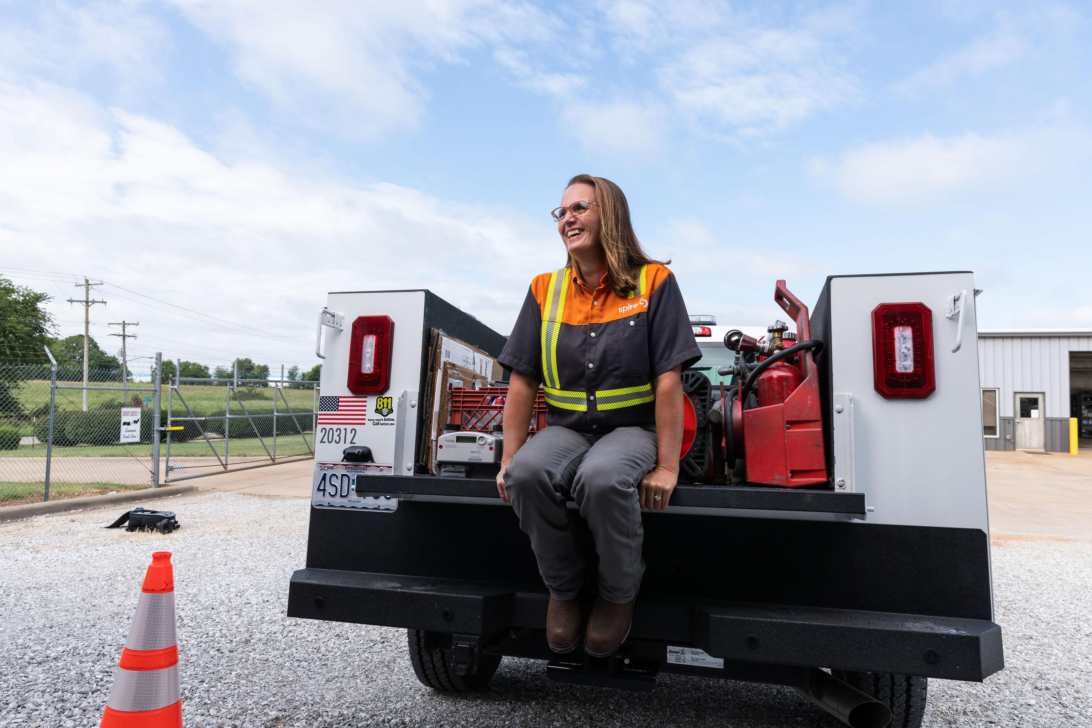 Image of female Spire employee on the back of a truck