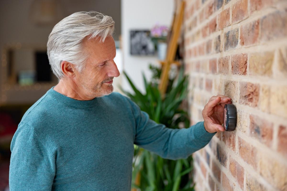 Man adjusting thermostat