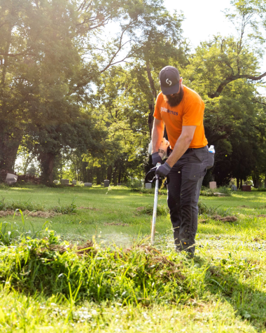 Spire Employee cutting grass in cemetery