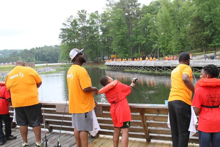 adults and kids fishing off pier